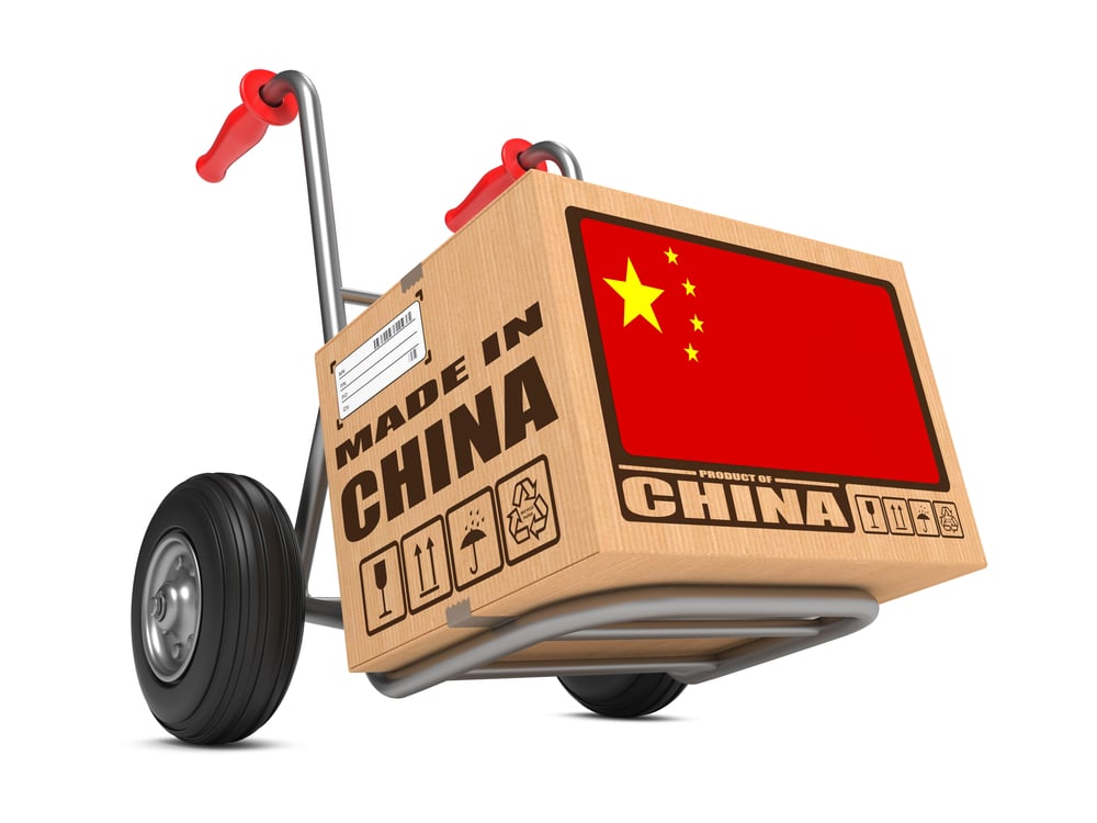 Cardboard Box with Flag of China and Made in China Slogan on Hand Truck White Background. Free Shipping Concept.