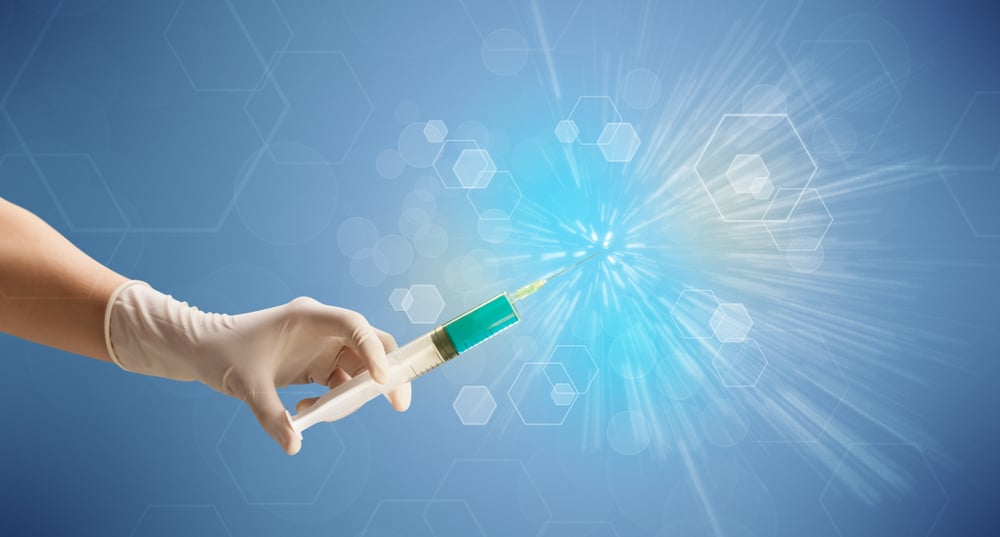 Female doctor hand holding syringe with shiny background