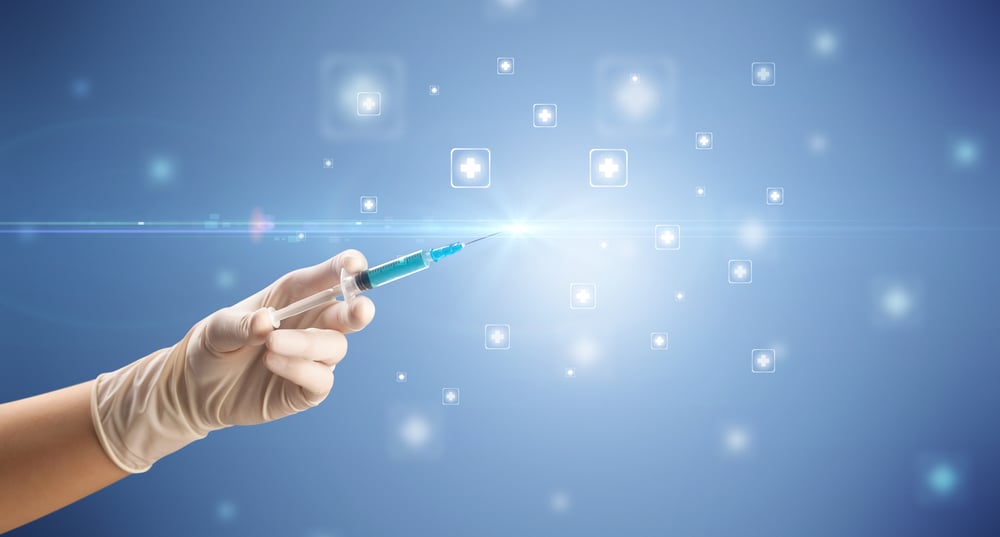 Female doctor hand holding syringe with shiny crosses in the background
