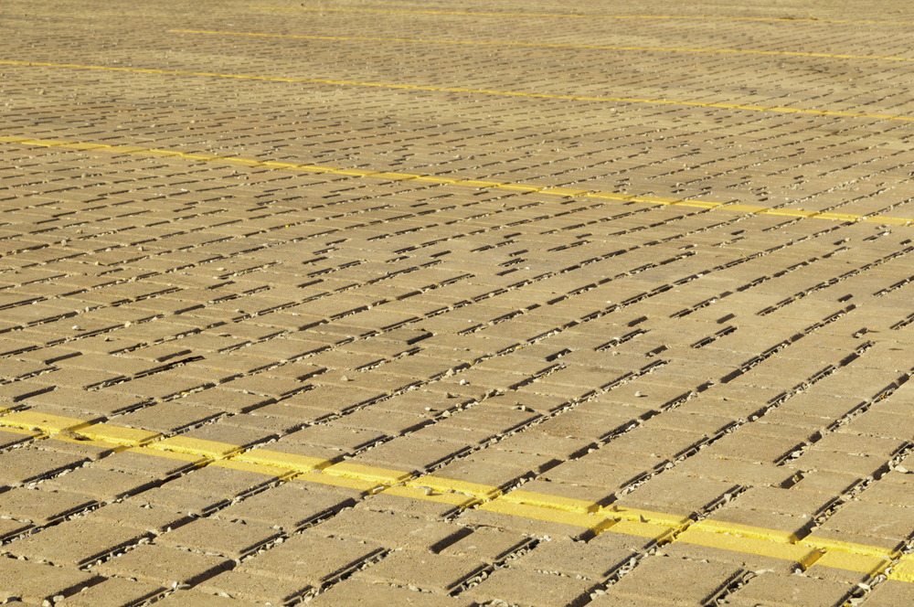 Parking lot made of paving stones, with yellow stripes