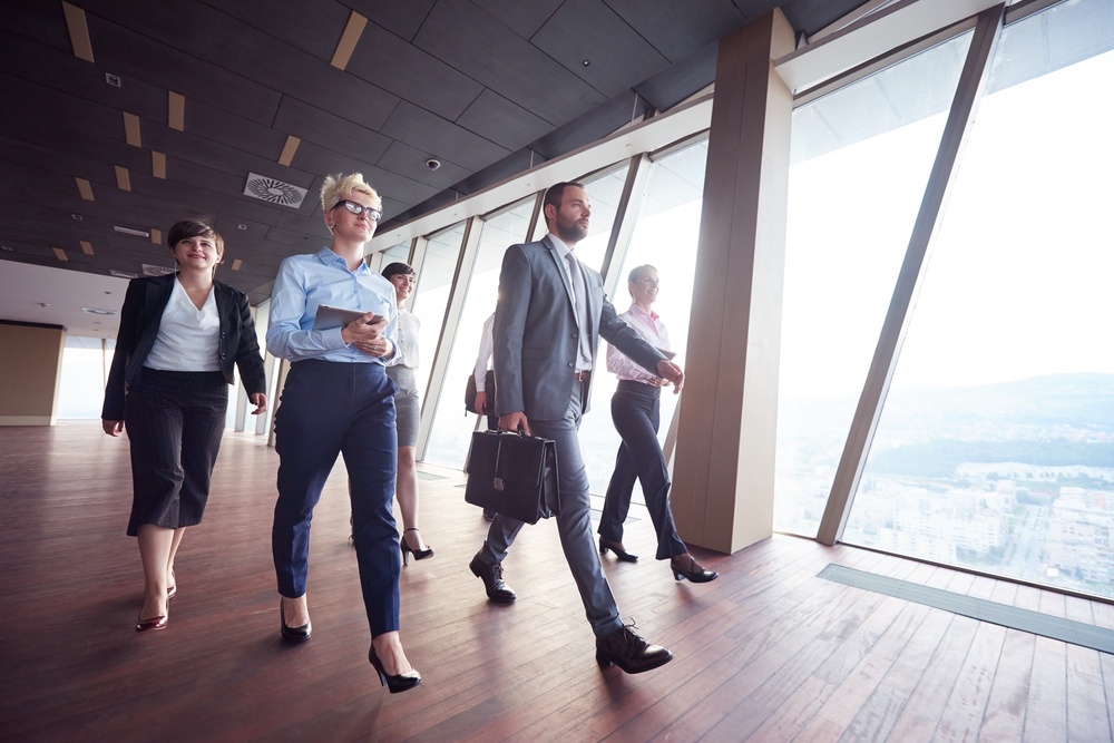 business team, businesspeople group walking at modern bright office interior