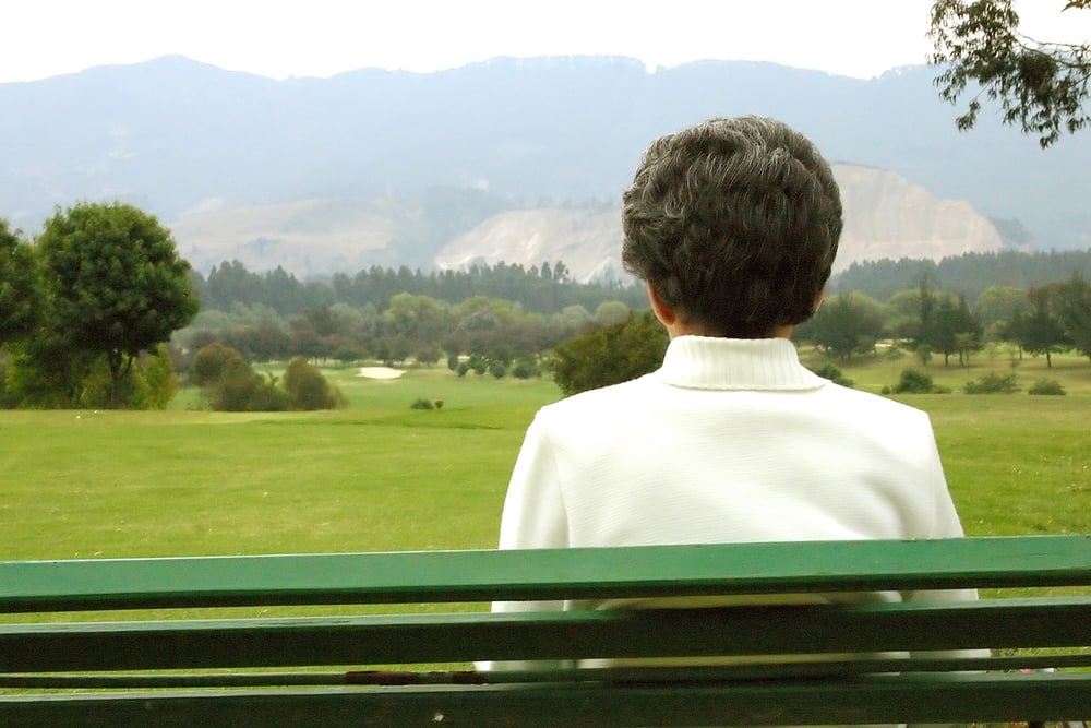 elderly woman on a bench in the countryside